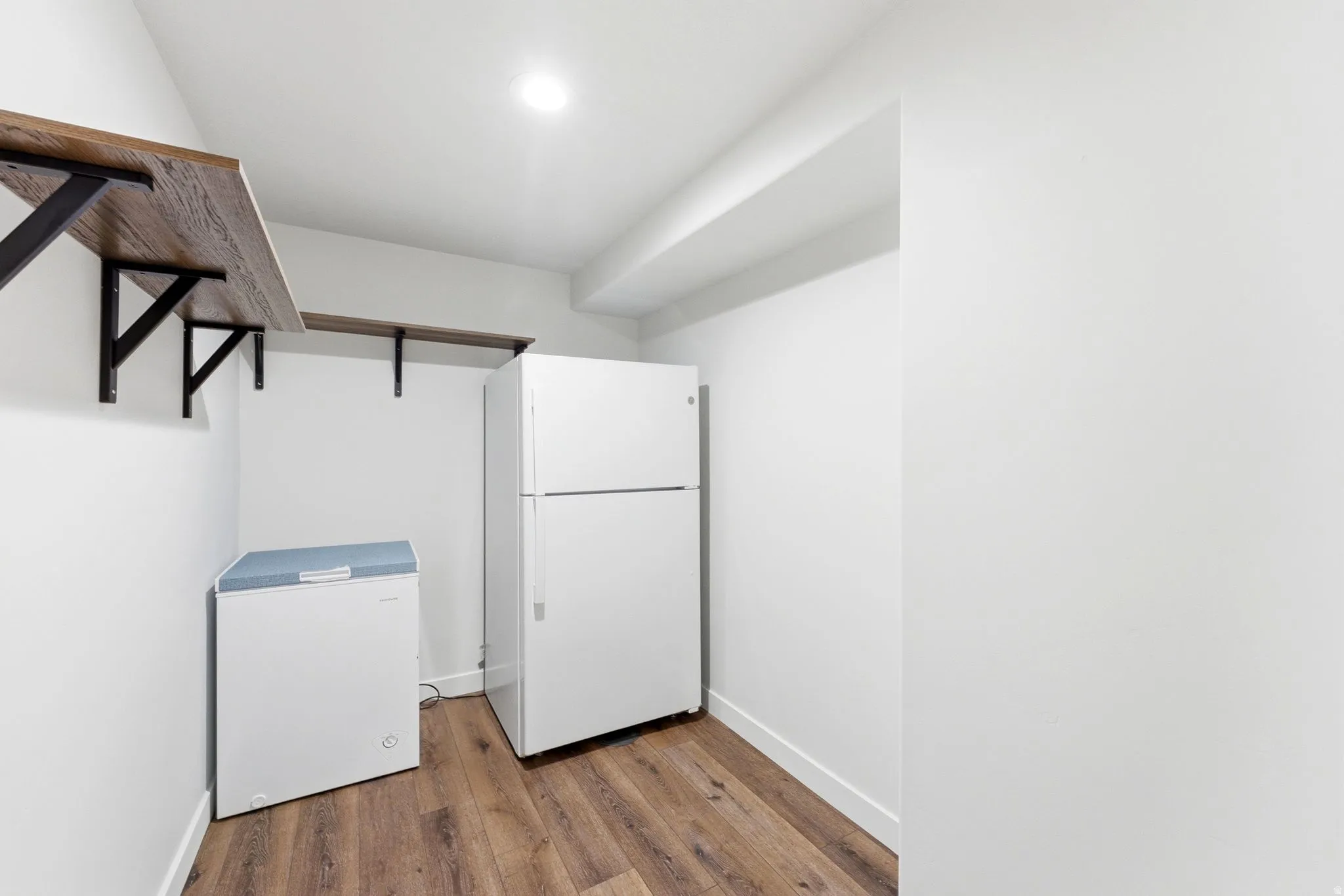Laundry area with dark wood-style floors and baseboards