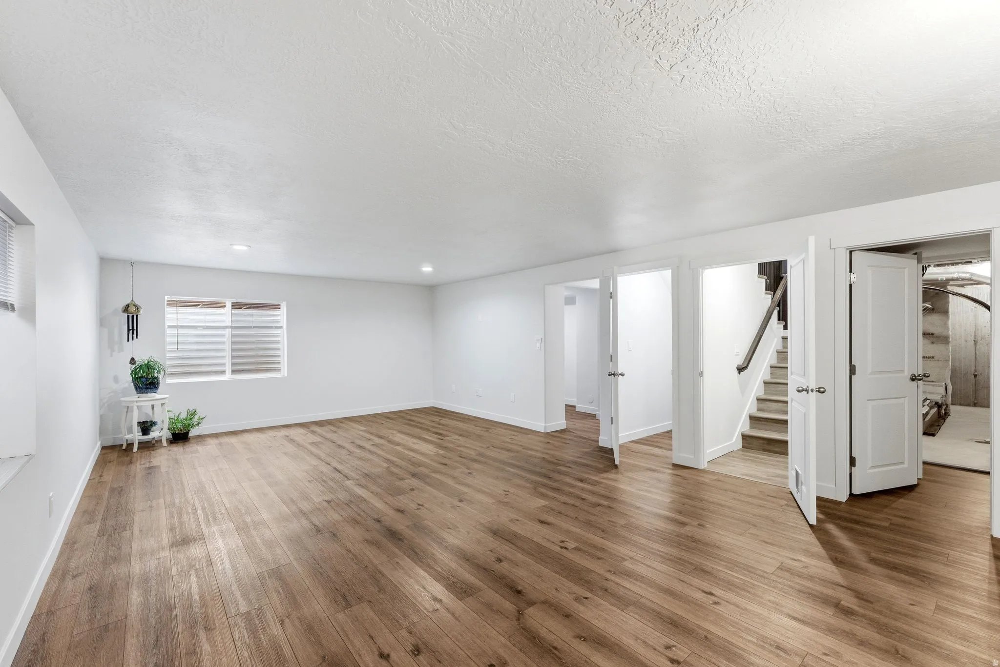 Below grade area with wood finished floors and a textured ceiling