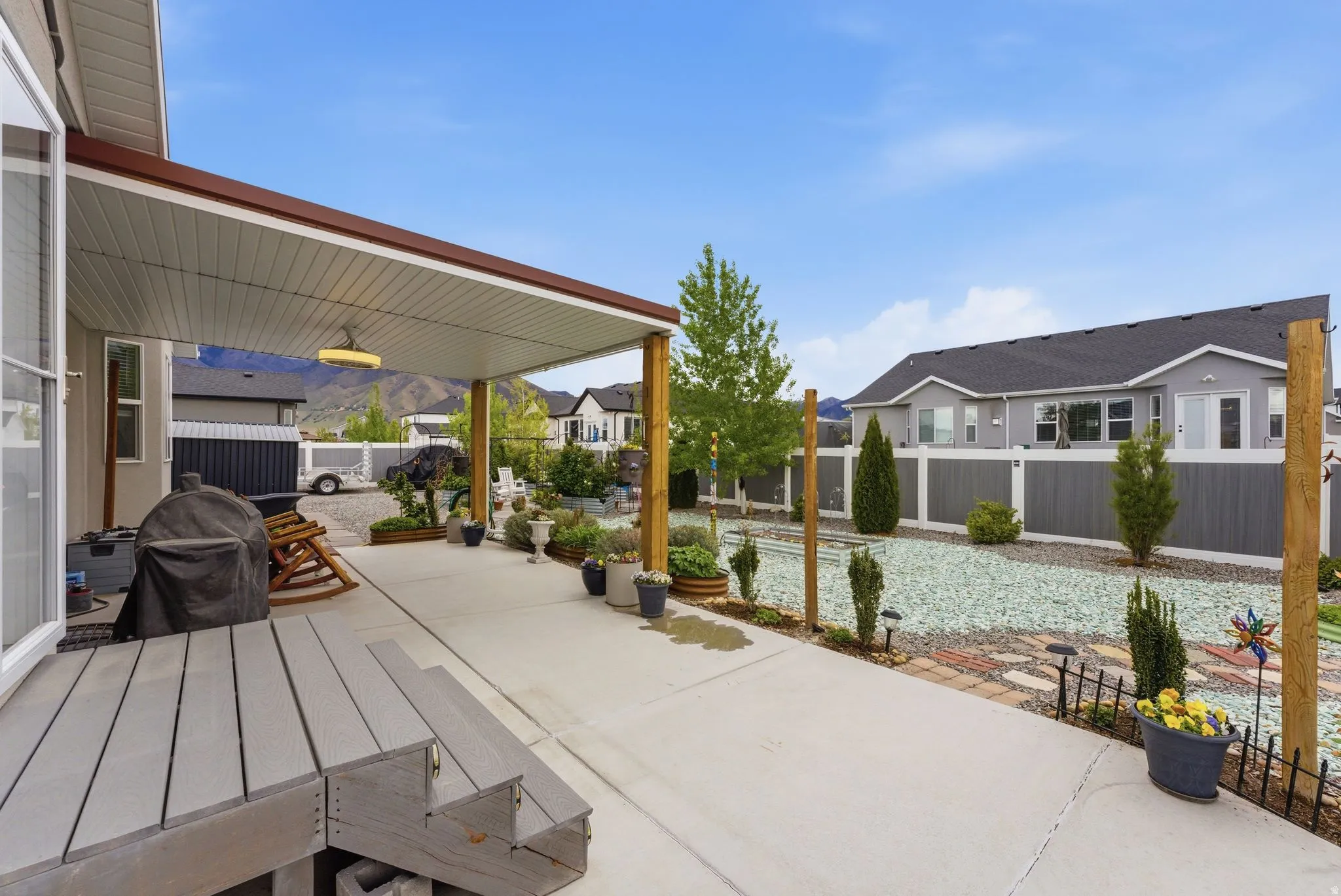 Fenced backyard with a residential view, area for grilling, a patio, and a mountain view