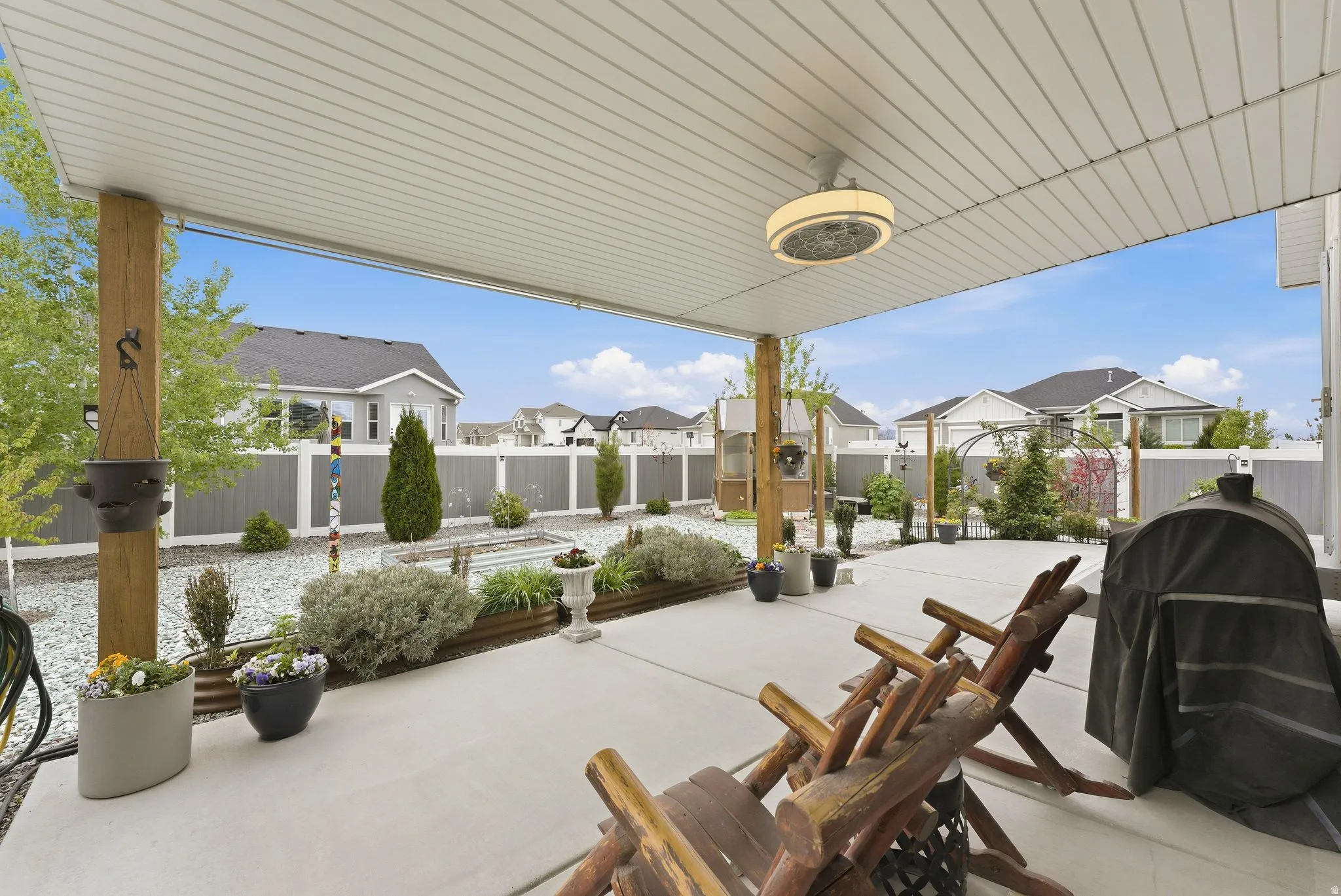 Fenced backyard with a residential view, a grill, and a patio area