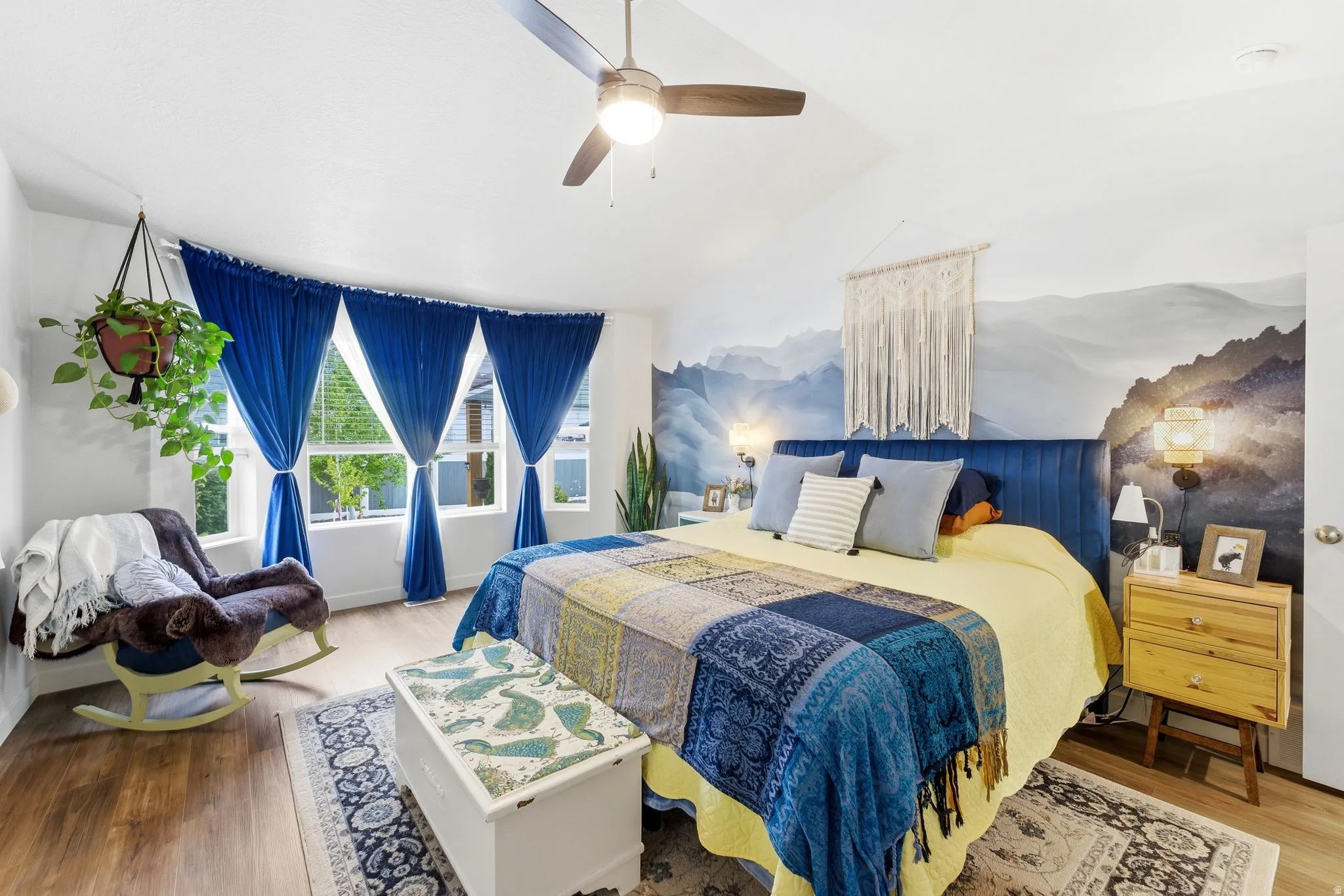 Bedroom with light wood-style floors, vaulted ceiling, and ceiling fan