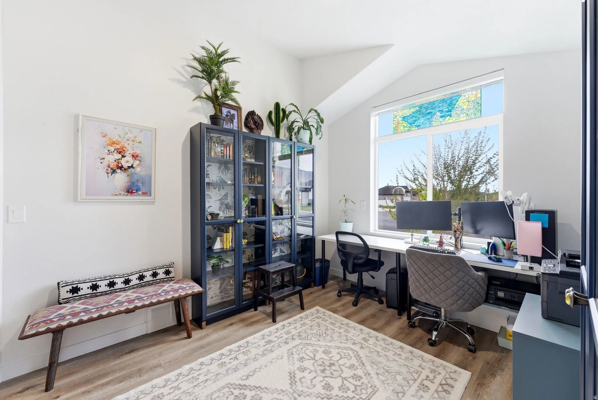 Office space with light wood finished floors and vaulted ceiling