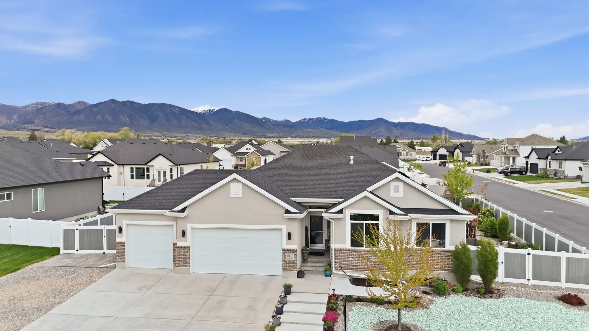View of front of house with a gate, a residential view, a garage, stucco siding, and driveway