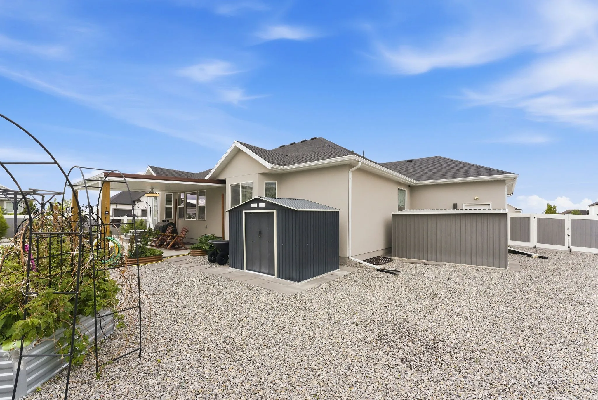 View of home's exterior with a shed, stucco siding, roof with shingles, and a fenced backyard
