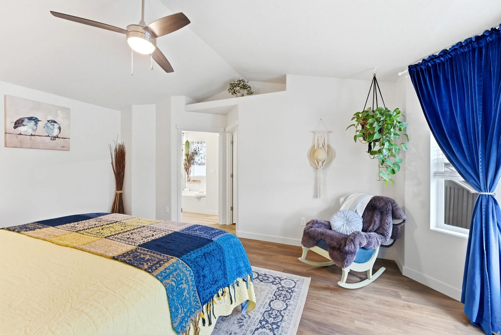 Bedroom with light wood-style floors, a ceiling fan, and connected bathroom
