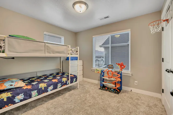 Bedroom featuring light colored carpet and a textured ceiling