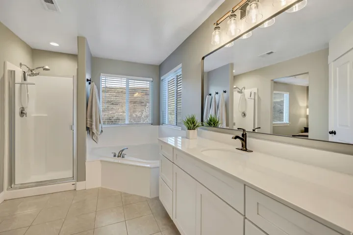 Full bathroom with a stall shower, vanity, a garden tub, and light tile patterned flooring