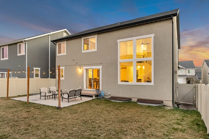 Back of property featuring a fenced backyard, a patio, and stucco siding