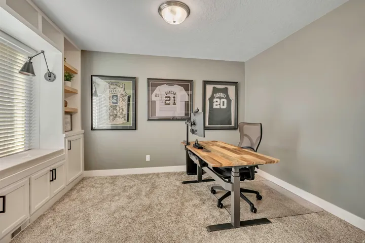Office space featuring light carpet and a textured ceiling