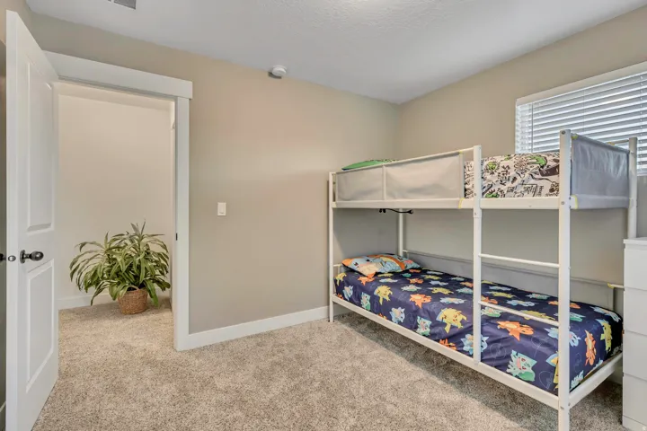 Bedroom with light colored carpet and a textured ceiling