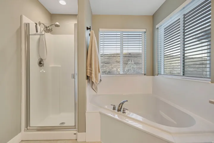 Bathroom with a stall shower and a bath