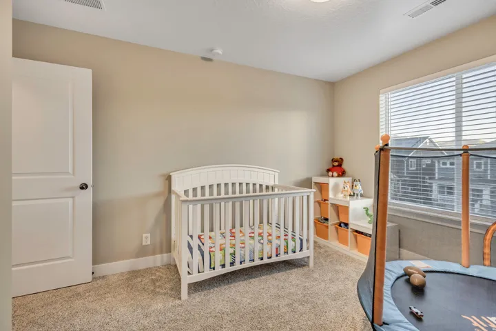 Bedroom featuring a crib and carpet