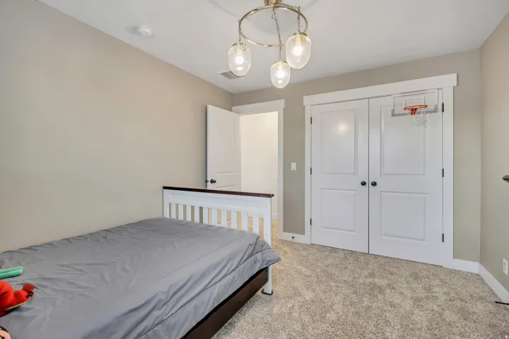 Bedroom with light carpet, a closet, and a chandelier