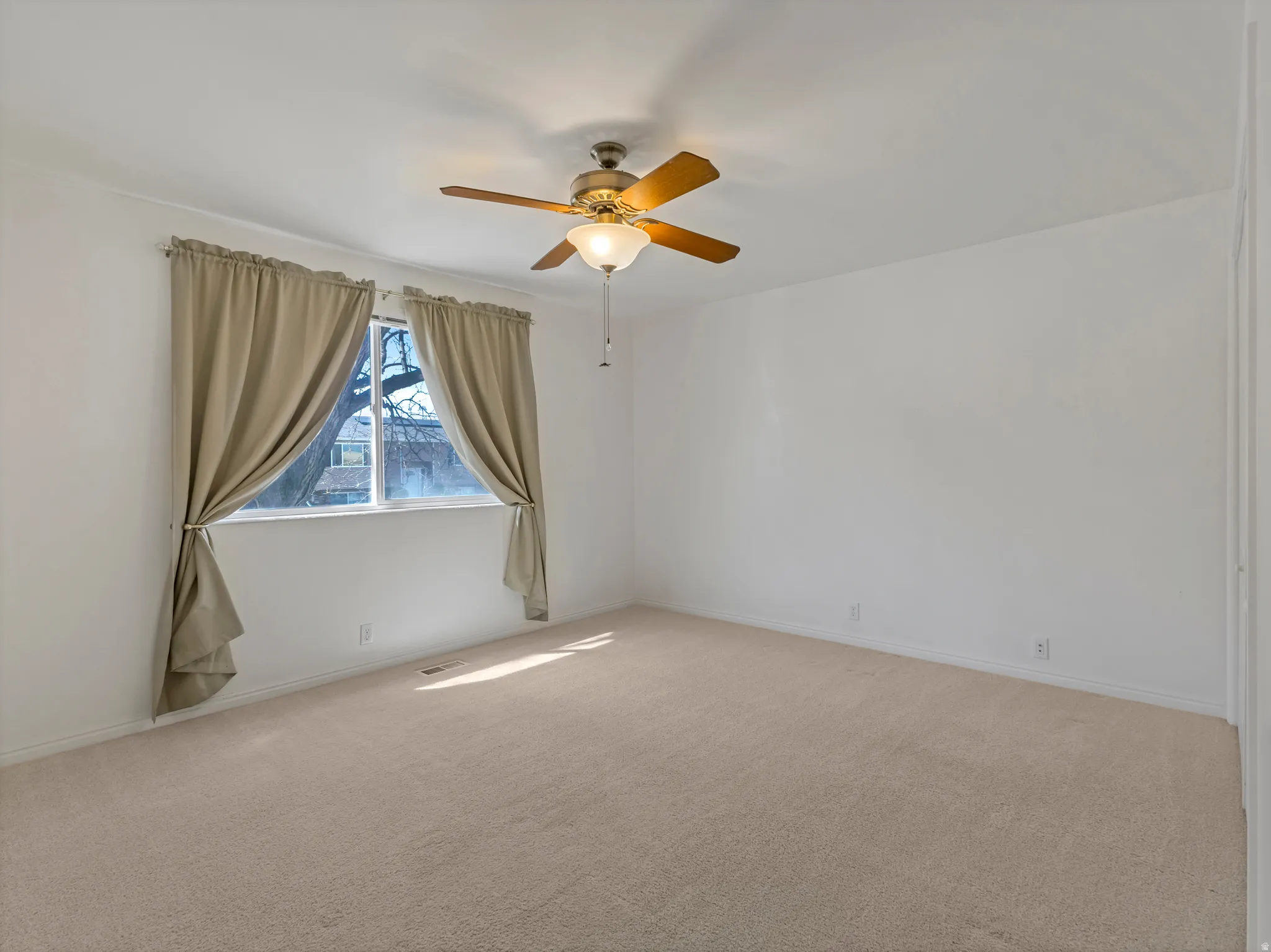 Empty room with ceiling fan and carpet floors