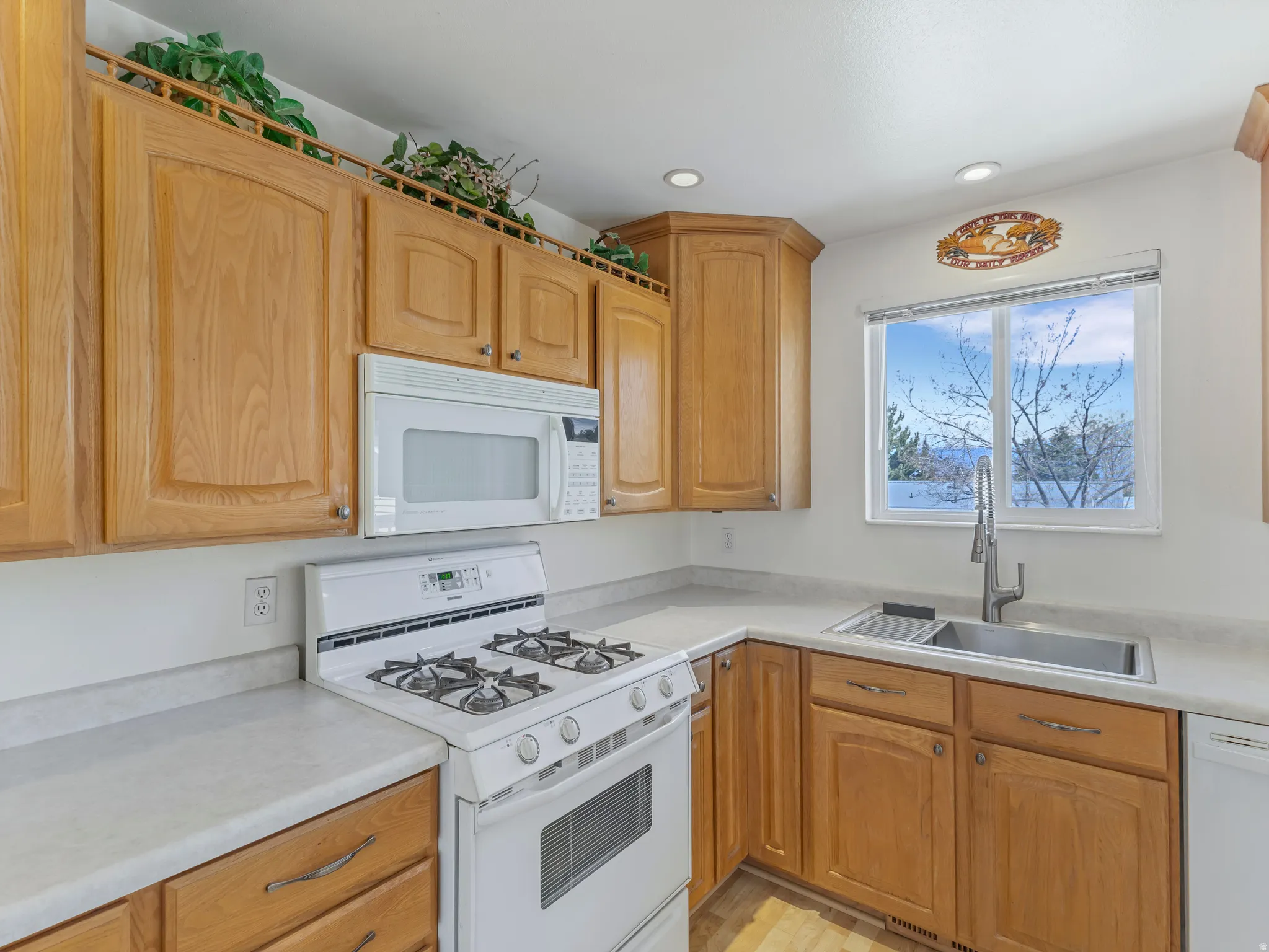 Kitchen with white appliances, light countertops, and recessed lighting
