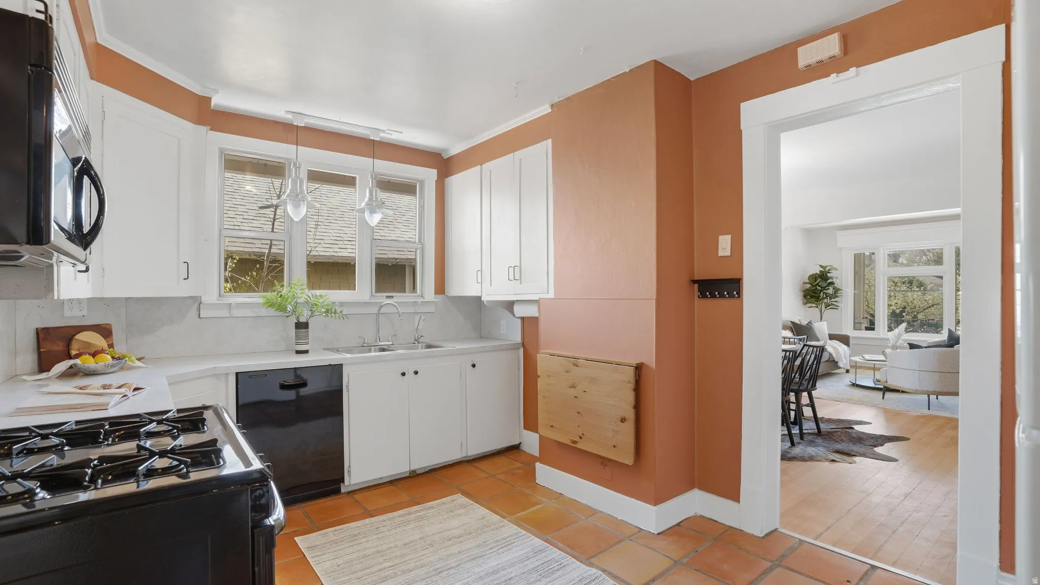 Kitchen featuring white cabinetry, range with gas cooktop, black dishwasher, and tasteful backsplash