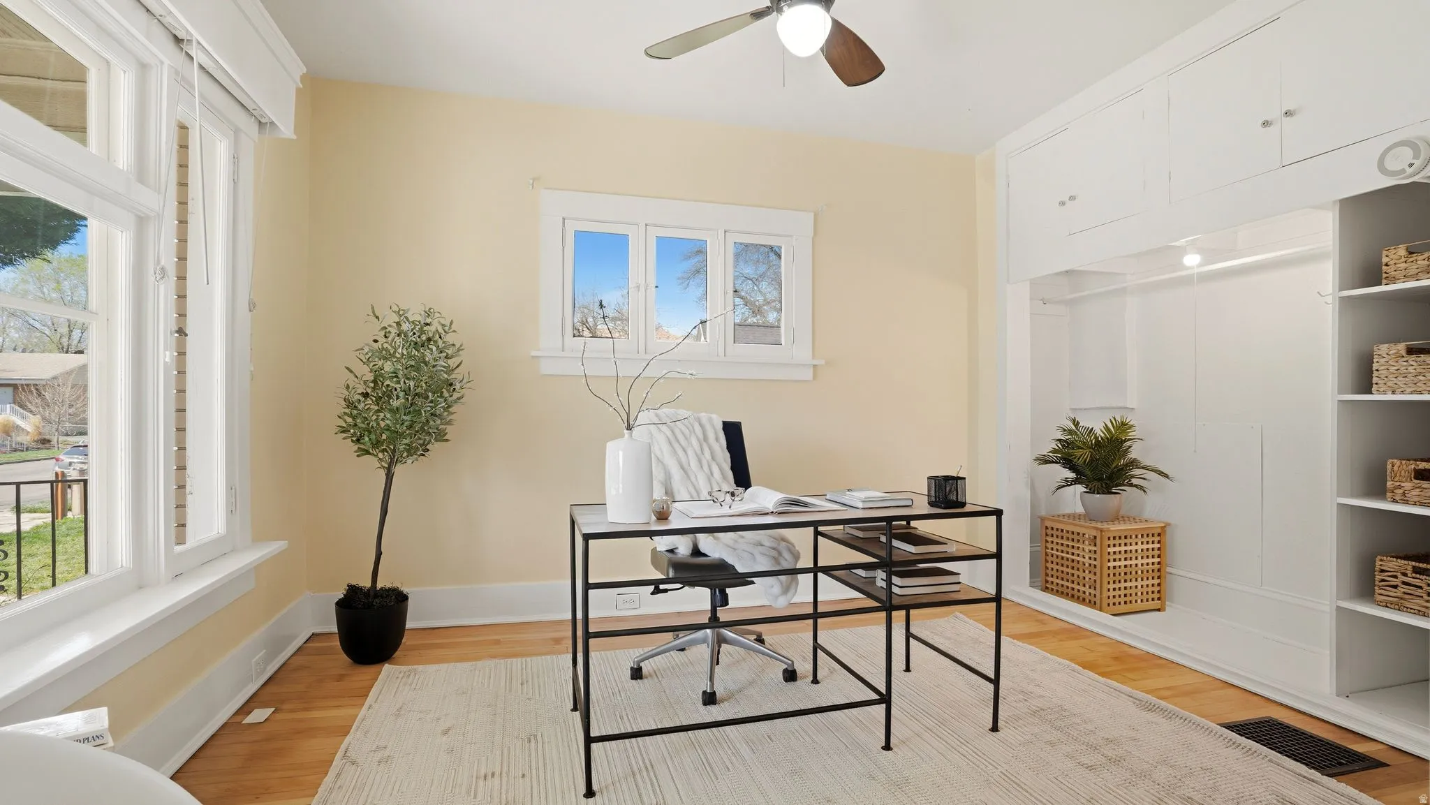 Office space with light wood finished floors and ceiling fan