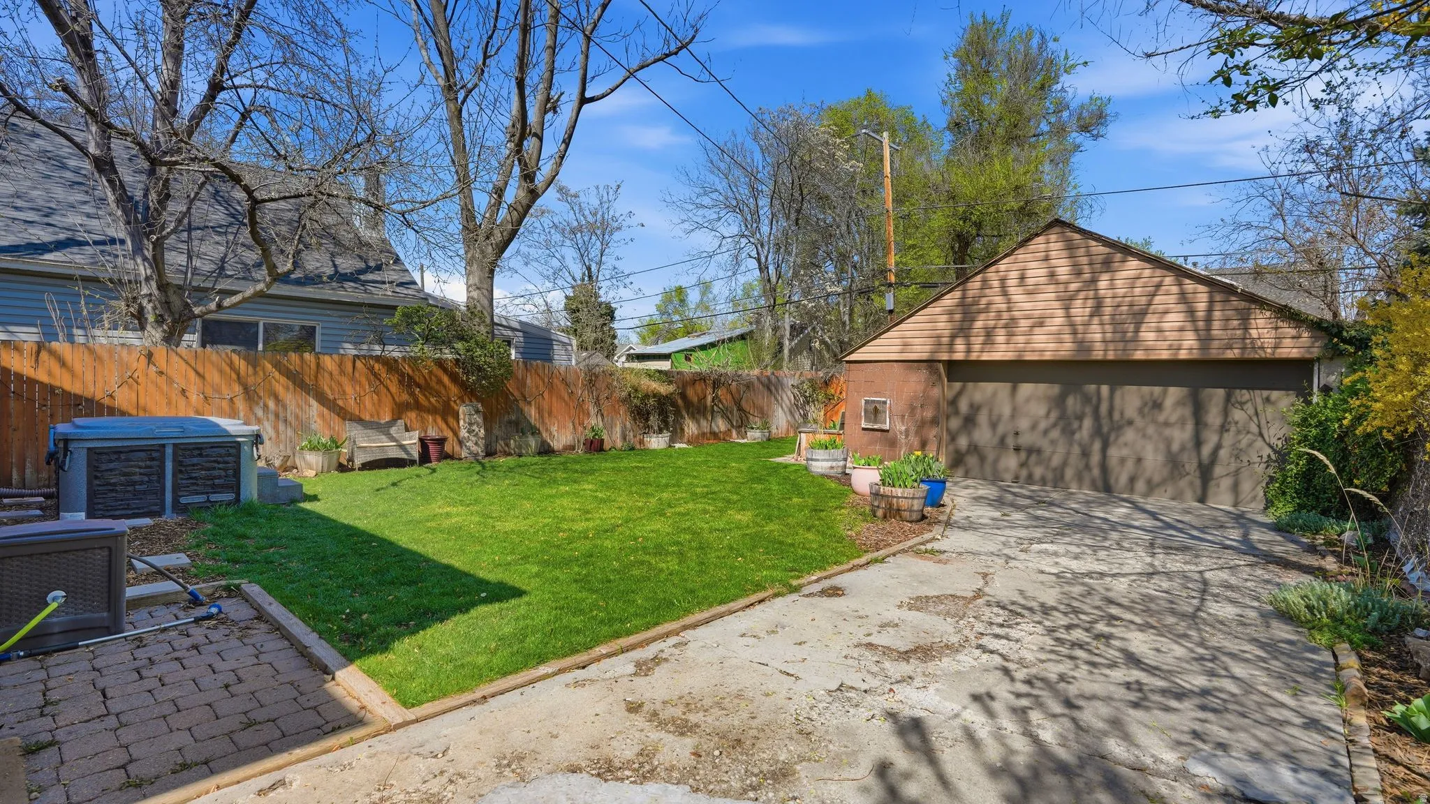 Fenced backyard featuring a garage and a patio