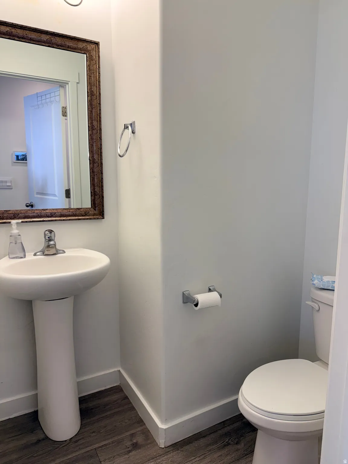 Bathroom featuring baseboards and dark wood-style flooring