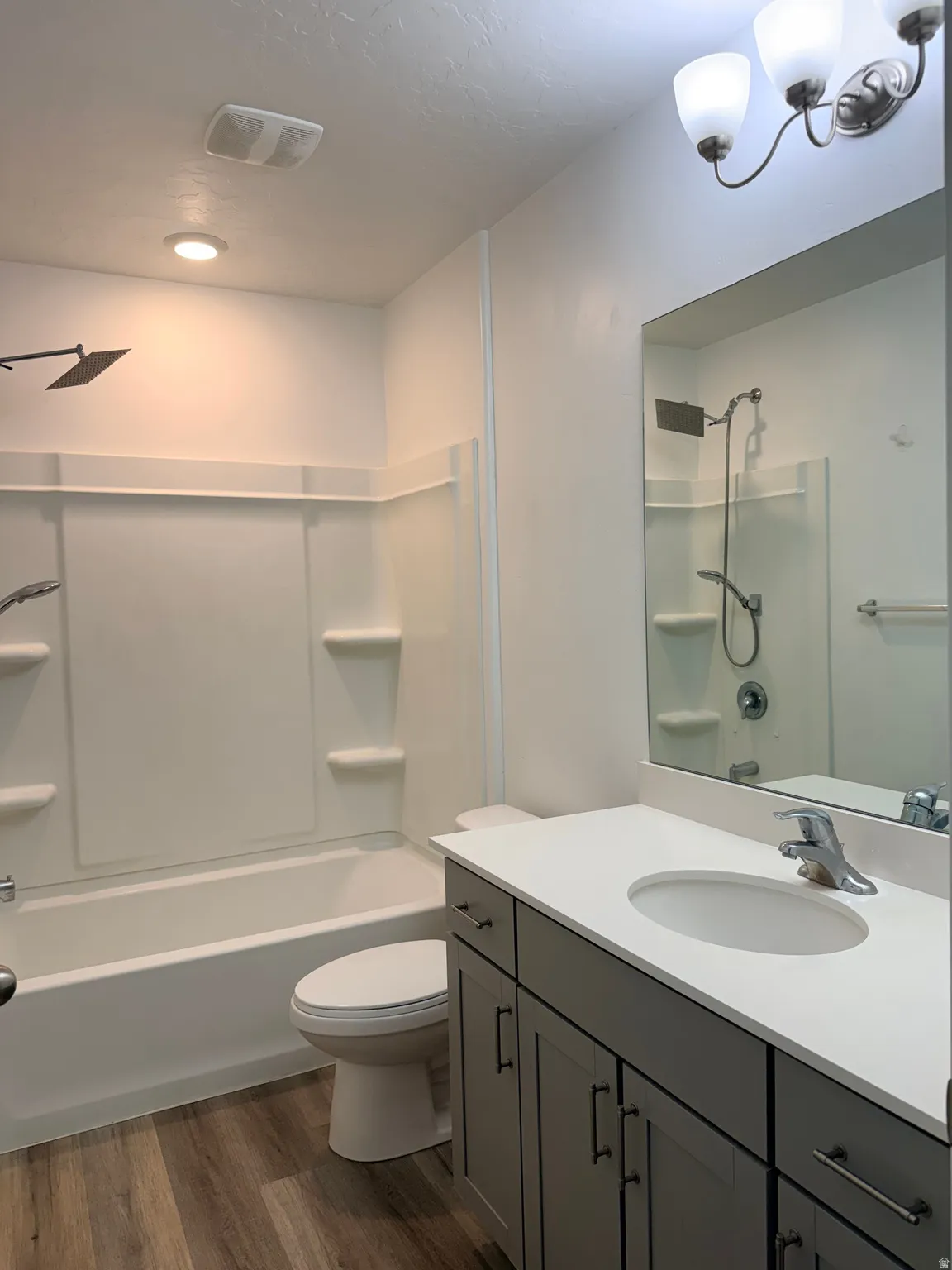 Full bath featuring tub / shower combination, dark wood finished floors, and vanity