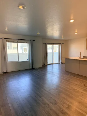 Unfurnished living room featuring dark wood finished floors and recessed lighting