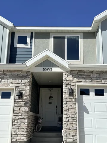 View of exterior entry featuring stone siding and an attached garage