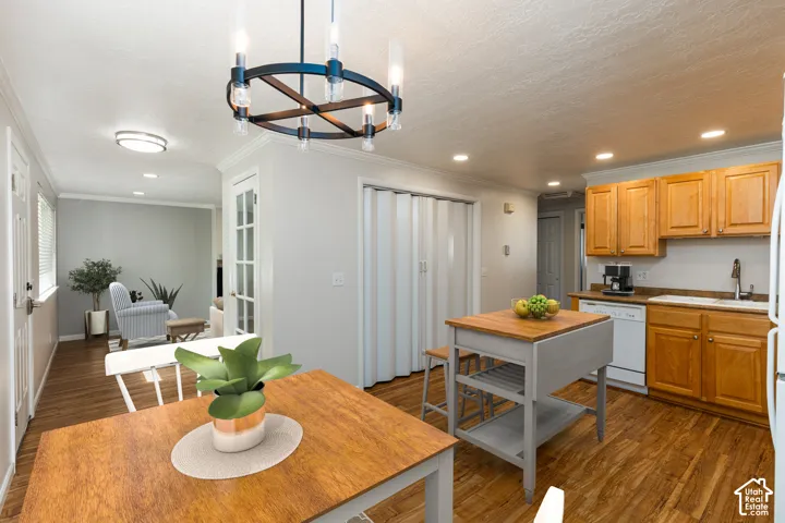 Wood-finish flooring throughout, with a kitchen featuring wood cabinetry and white appliances