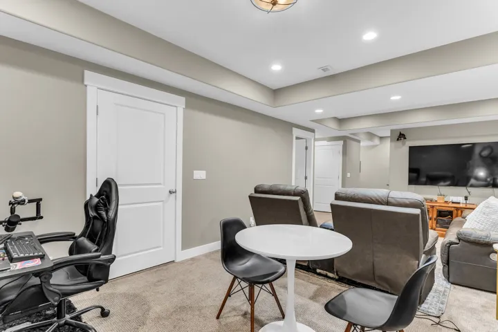 Recessed lighting, light gray wall color, carpeted flooring, white trim, and a white interior door