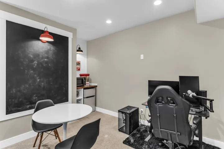 Integrated chalkboard wall with a red sconce, recessed lighting, built-in shelving, and a compact refrigeration unit