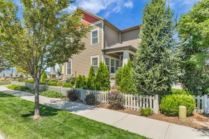 Exterior showcasing tan horizontal siding, white trim windows, and a covered entry