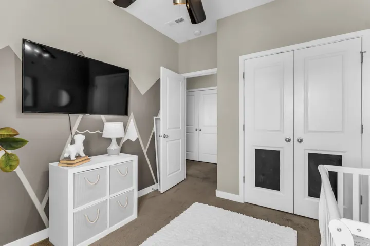 Wall-mounted television, two-panel interior doors, and neutral wall color