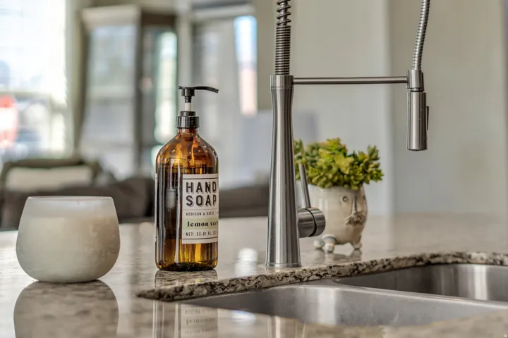 Kitchen view of a sink and light stone countertops