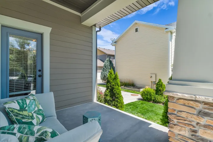 Covered patio with concrete flooring, plank siding, and a glass-paneled door