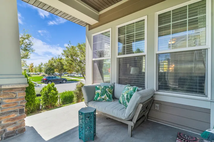 Covered porch featuring a stone column base and concrete flooring