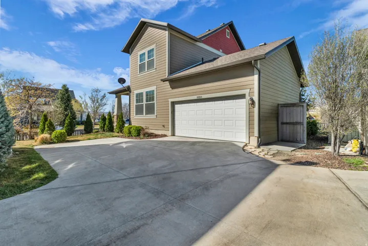 View of home's exterior featuring concrete driveway, a garage, and a shingled roof