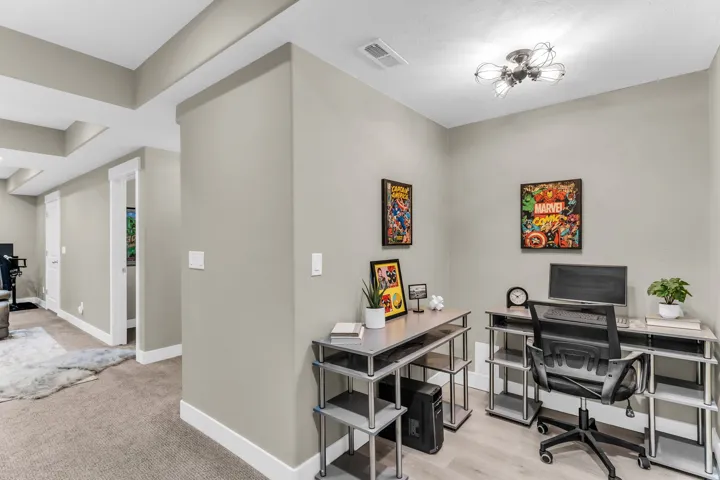 Recessed lighting, tray ceiling, neutral wall color, white trim, and wood-finish flooring