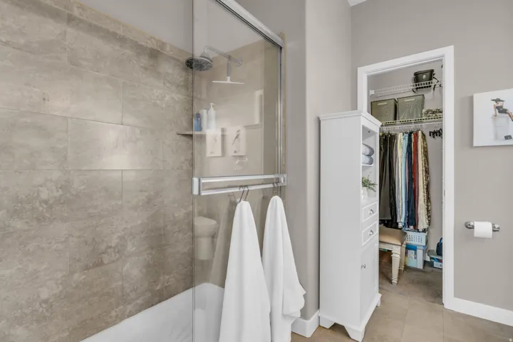 Bathroom featuring a shower stall and a spacious closet