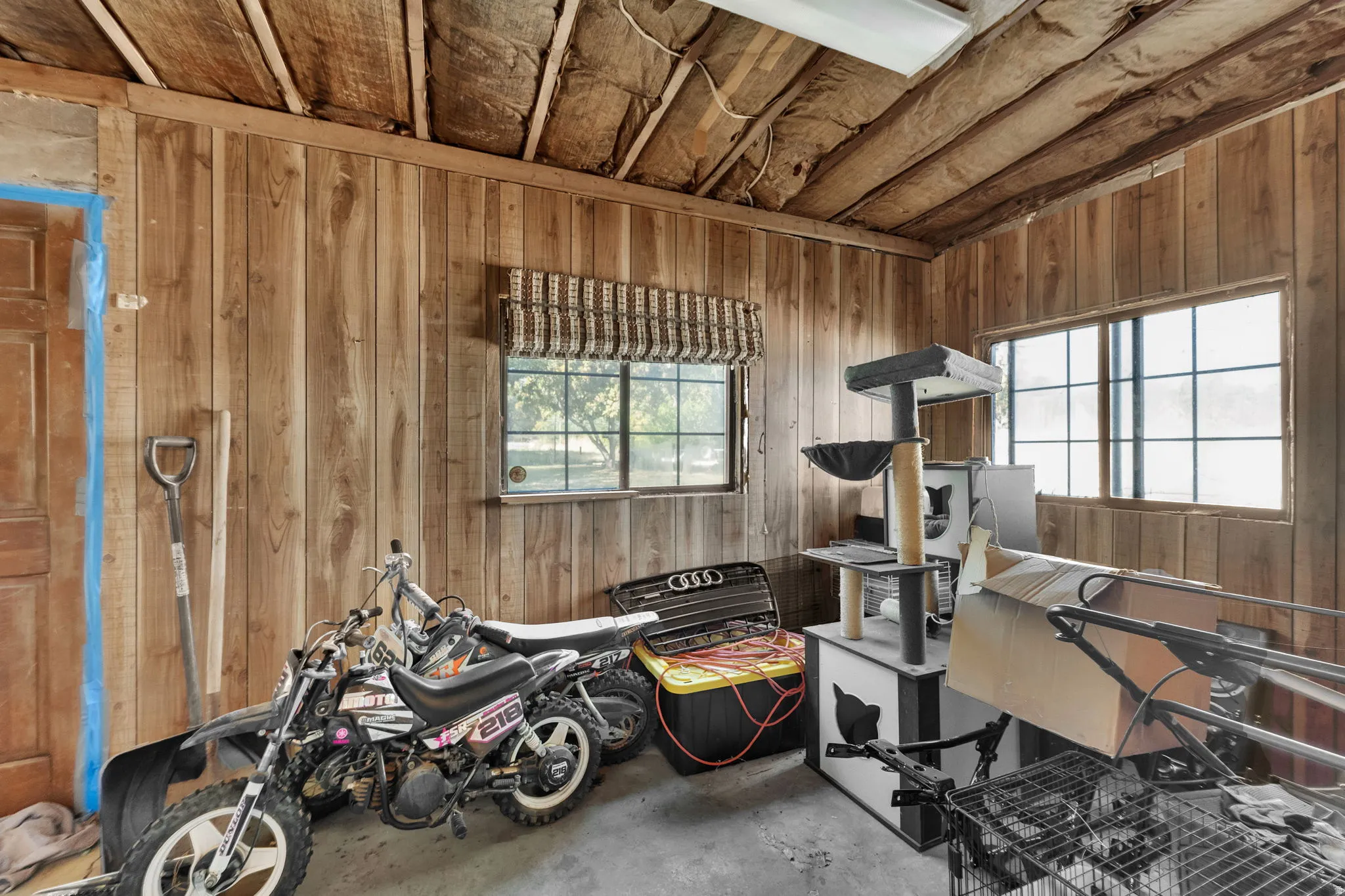 Miscellaneous room featuring wood walls and concrete floors