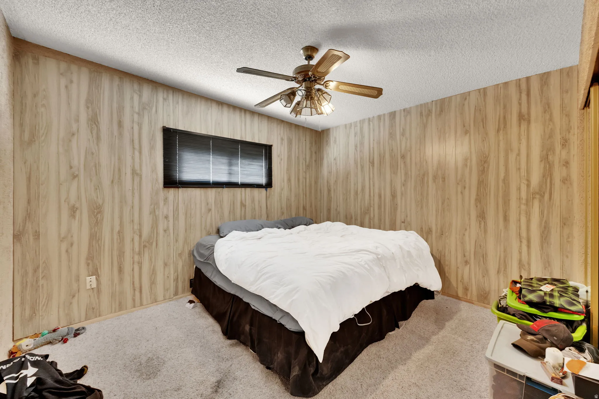 Carpeted bedroom featuring ceiling fan and a textured ceiling