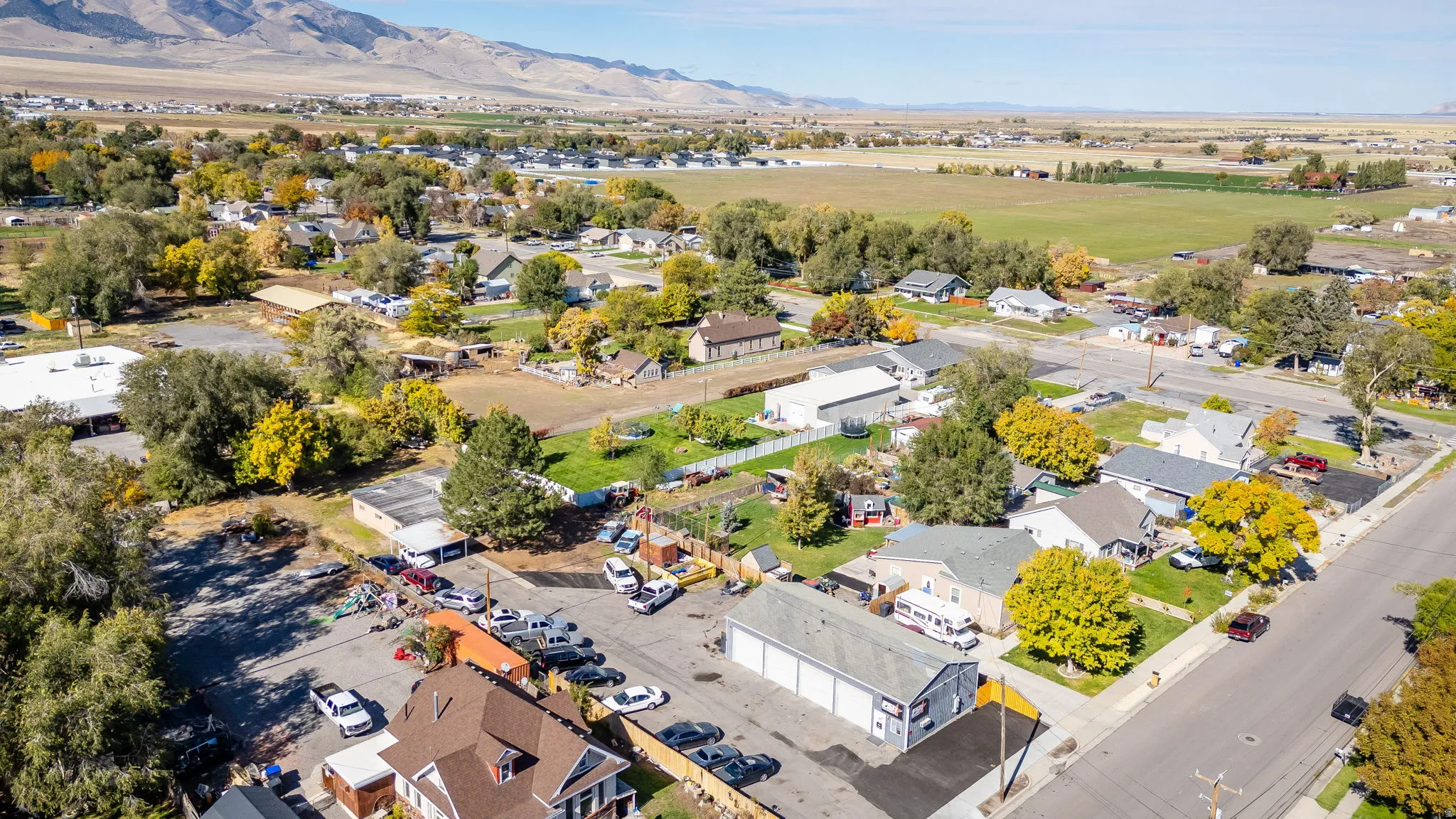 Aerial view of property and surrounding area with mountains and nearby suburban area