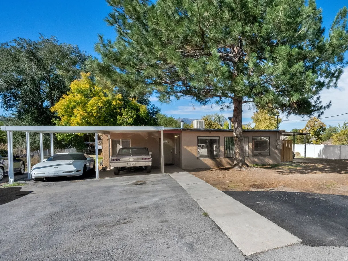 View of front of property with a carport and driveway