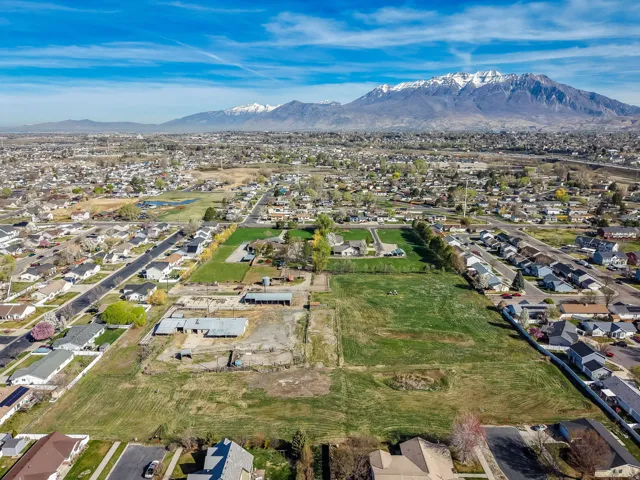 Aerial view of property and surrounding area with nearby suburban area and mountains