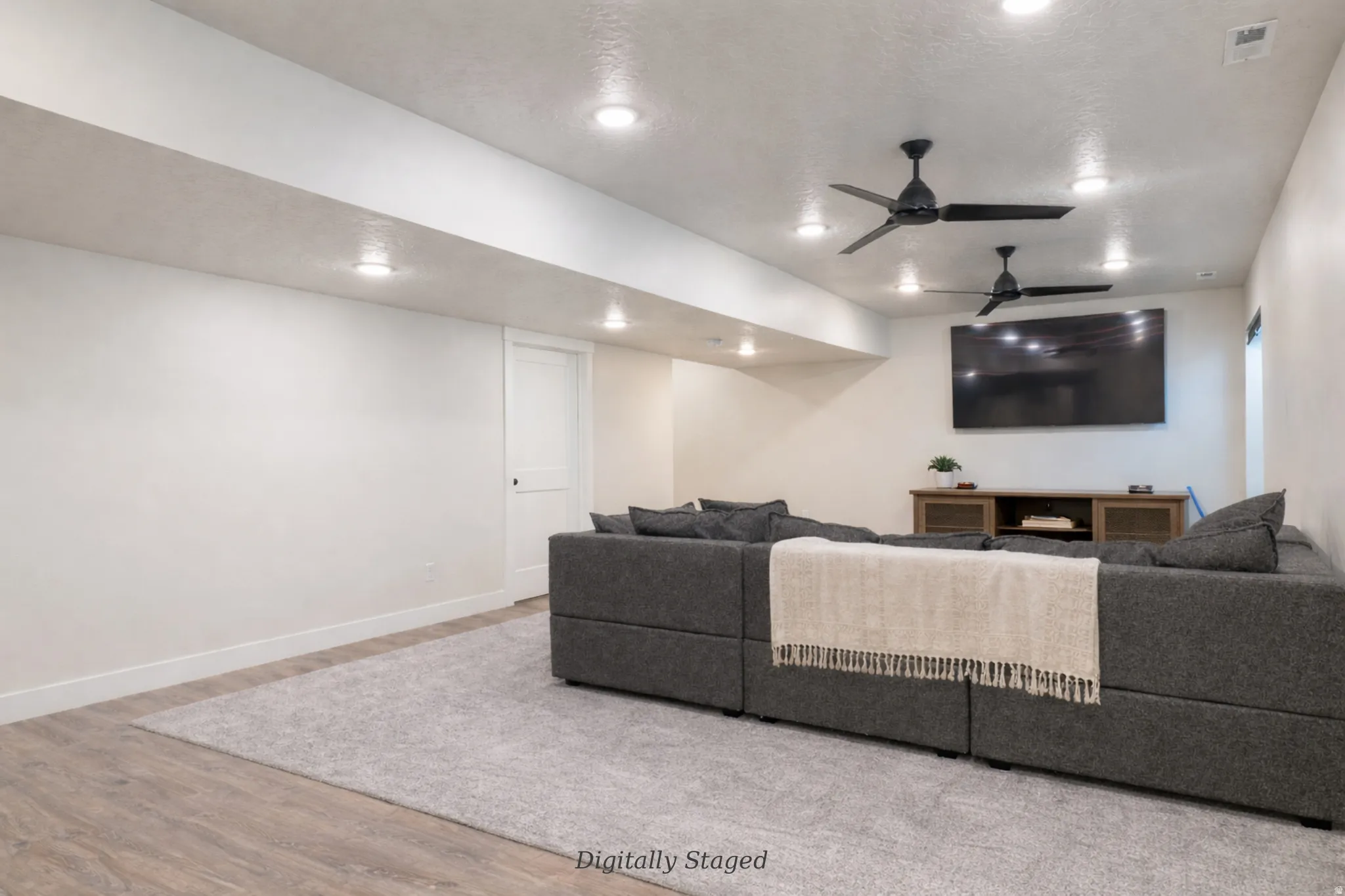 Living room featuring light wood-type flooring, ceiling fan, and recessed lighting