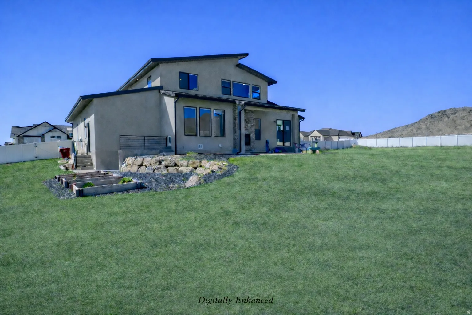 Back of property featuring a fenced backyard, stucco siding, a mountain view, and a garden