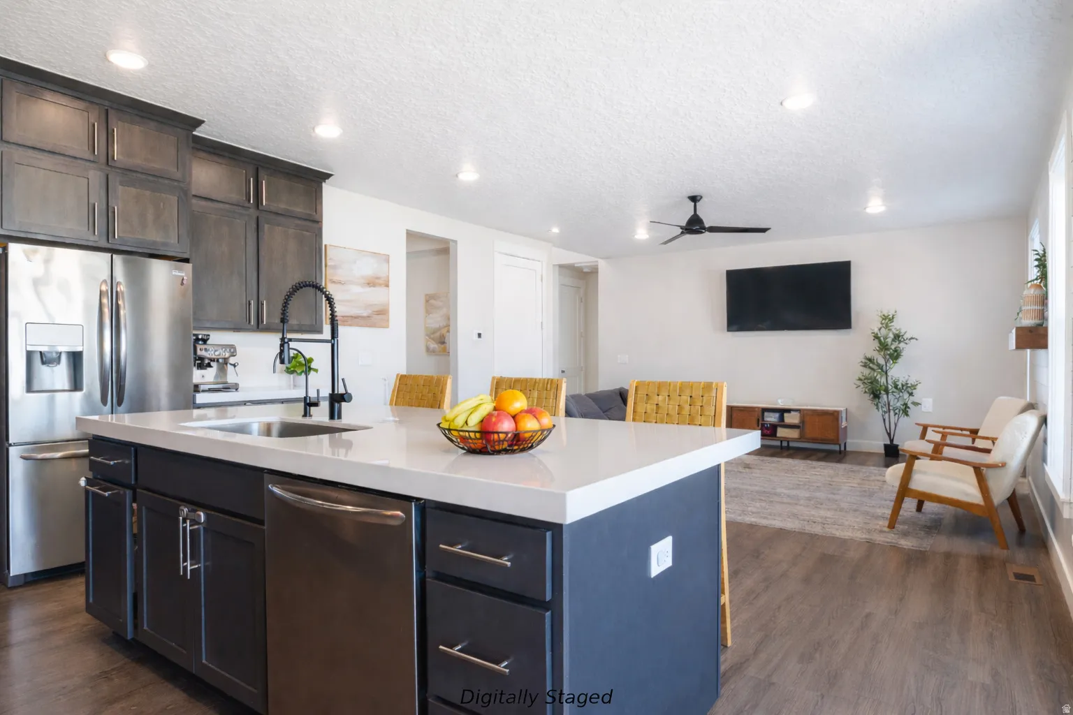 Kitchen with stainless steel appliances, open floor plan, dark wood finished floors, a textured ceiling, and light stone countertops
