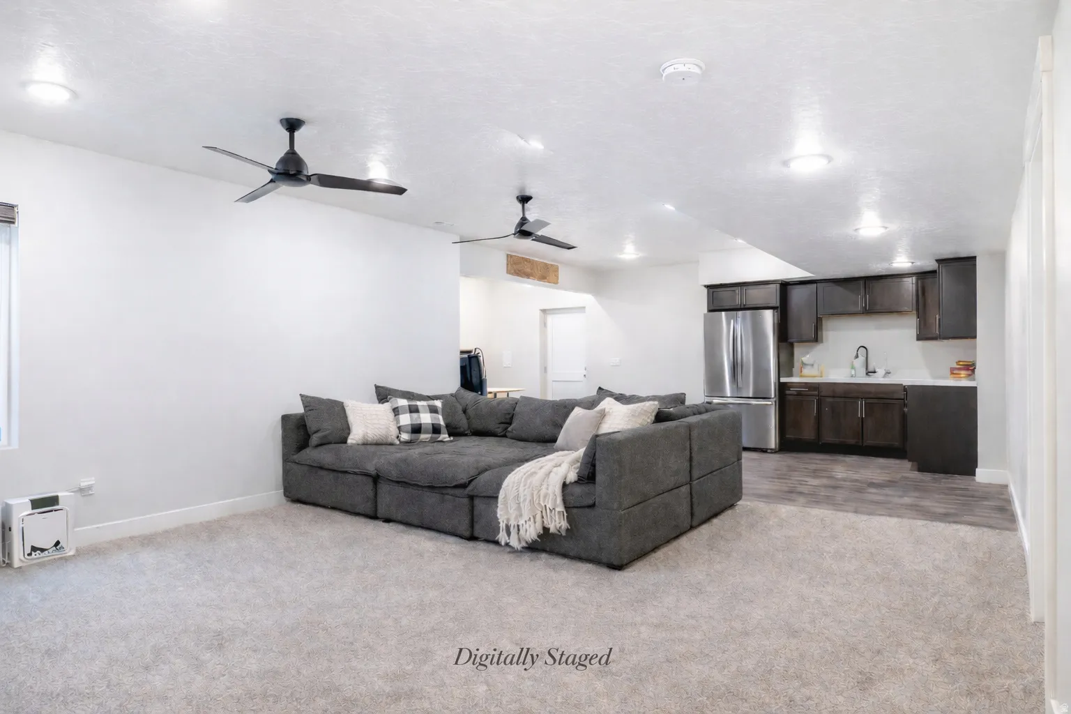 Living area with light carpet, a ceiling fan, and recessed lighting