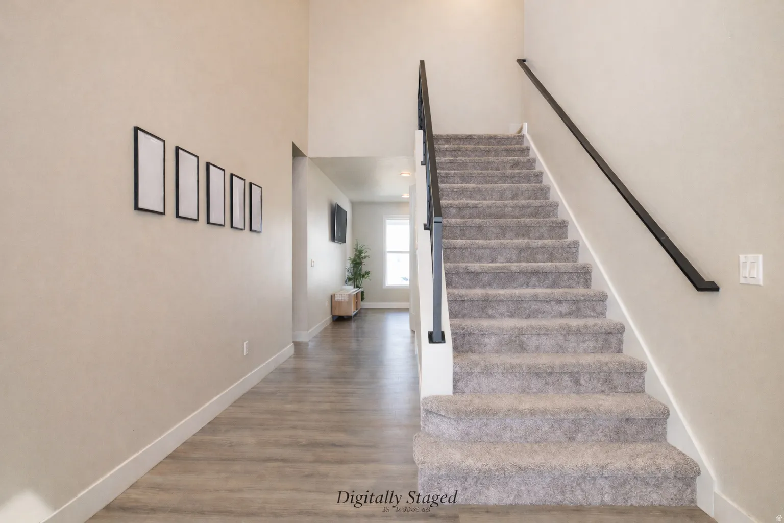 Stairs featuring wood finished floors and a high ceiling