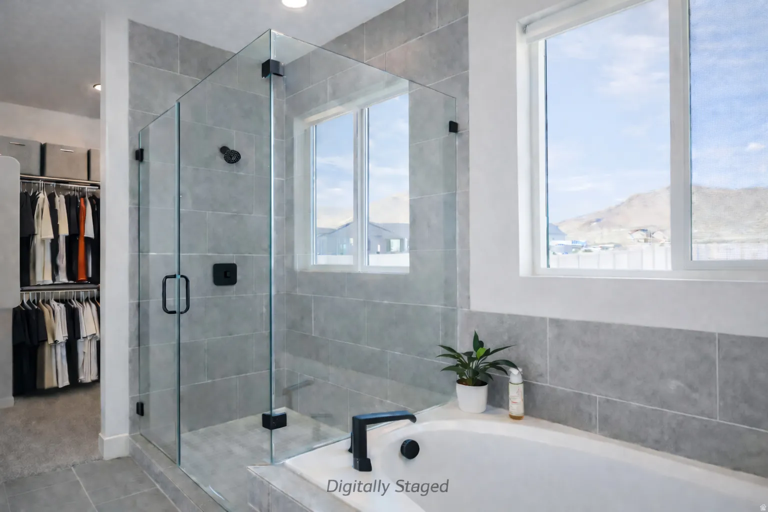 Bathroom with a walk in closet, a stall shower, and a bath