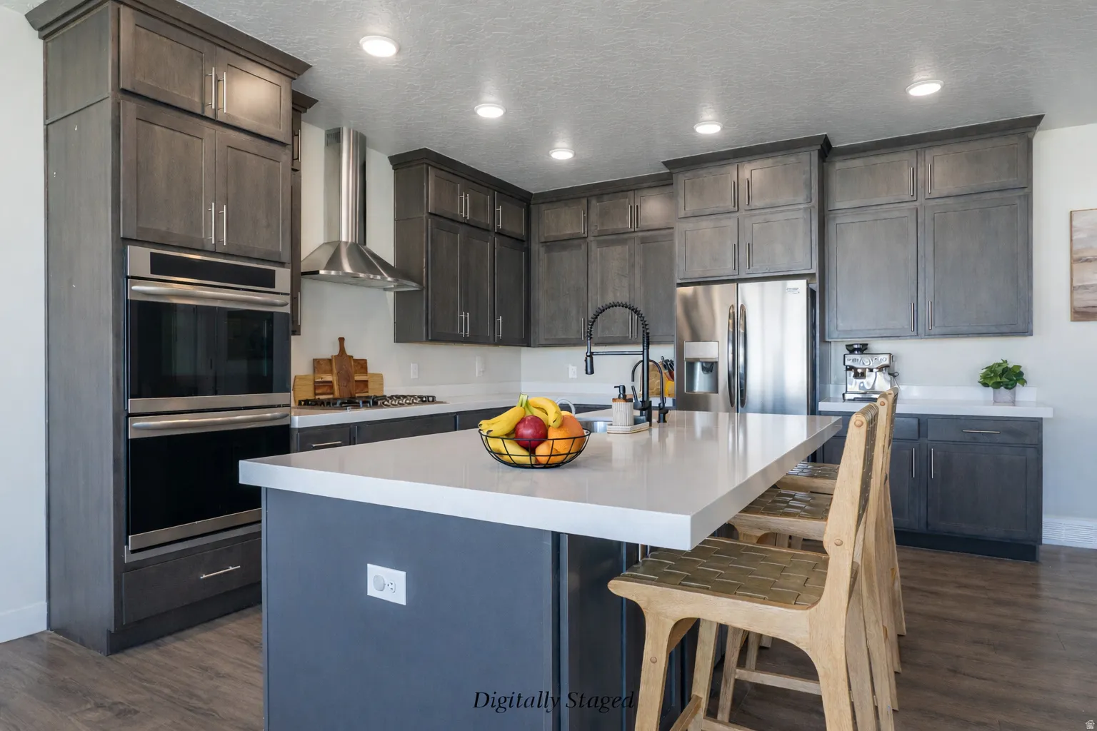 Kitchen featuring stainless steel appliances, a kitchen bar, dark wood-style floors, a kitchen island with sink, and recessed lighting