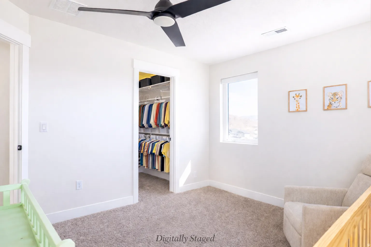 Bedroom with a spacious closet, light colored carpet, and a ceiling fan